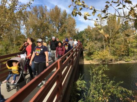 Participants walking across a bridge in Julia Davis park.