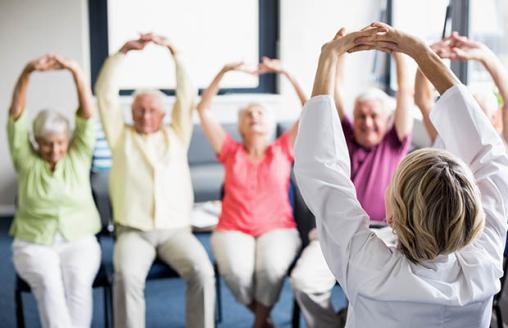 A group of seniors performing chair-based exercises